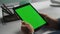 Executive hold green tablet device at workplace. Freelancer talk job interview