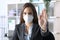 Executive wearing mask doing stop gesture at office