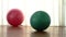 Exercise balls of pink and turquoise colours on wooden floor