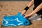 Exercise equipment, Woman`s hands rolling yoga mat on the sea beach