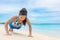 Exercise fitness push up training girl doing bodyweight workout on beach. Asian woman fit active lifestyle