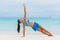 Exercise fitness yoga girl training side plank on beach. Core body workout woman planking in blue clothing activewear, healthy