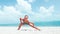 Exercise woman stretching on beach. Fitness sport model smiling happy stretching legs during outdoor work out on sunny