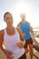 Exercise, you dont have time not to. a young couple jogging together on the promenade.