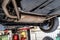 The exhaust system in the car seen from below, the car is on the lift in the car workshop.