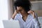 Exhausted African American young woman taking off glasses close up