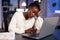 Exhausted african freelancer resting head on hand in front of laptop