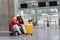 Exhausted African man on a long night connection at airport, waiting for a plane sitting in terminal