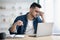 Exhausted arab guy sitting at workdesk, removing glasses