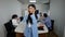 Exhausted Asian slim woman rubbing temples and yawning standing in office with blurred coworkers at background. Portrait