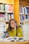 Exhausted beautiful student studying between piles of books