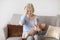 Exhausted blonde woman having migraine, holding little baby, home interior