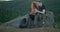 Exhausted Couple Drinking Tea After Hike, Sitting On Rock In Mountain Cliff