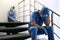 Exhausted doctors sitting on stairs indoors. Stress of health care workers during COVID-19 pandemic