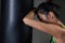 Exhausted female boxer leaning on punching bag