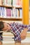 Exhausted handsome student resting head on piles of books