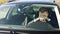 Exhausted male driver holding head in steering wheel while sitting in side modern luxury car. Caucasian businessman in