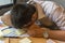 Exhausted man fall asleep on unorganized table with documents, sticky note