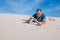 Exhausted man, lost in the desert opens a bottle of water