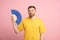 Exhausted man using paper fan suffer from heat. Overheating, stuffiness, hot weather concept