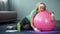 Exhausted mature female lying on fitness ball, relaxing after active workout