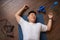 Exhausted mature korean man lying on yoga mat on floor with sports tools and bottle for water, top view