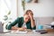 Exhausted schooler sitting at desk in his room, studying