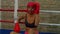 Exhausted sporty African woman fighter relaxing inside boxing ring after workout