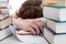 Exhausted student behind a books