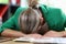 Exhausted and tired business woman lies on desktop in office.