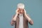 Exhausted young albino man suffering from headache, rubbing temples with closed eyes on blue studio background