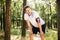 Exhausted young man athlete standing after running in forest