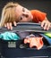 Exhausted young woman packing luggage