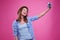 Exhilarated woman smiling while making selfie photo