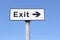 Exit arrow direction sign against blue sky