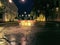 The exit road from the asphalt area is blocked by plastic barriers and road signs. Night cityscape