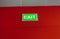 Exit sign glowing on red wall