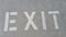 Exit written in white on concrete parking lot