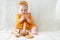 exited little baby girl plays with wooden toy pyramid sitting on couch