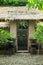 Exotic Bali house gate with hindu god face sculpture, traditional patterns and foliage