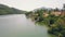 Exotic bungalows with thatched roof and boat pier on shore mountain lake in luxury hotel aerial view. Cottages on shore