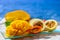 Exotic fruits, fresh ripe sweet yellow mango and passion fruits served on glass plate with blue seaview background