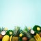 Exotic pineapples, ripe coconuts, banana, melon, lemon, tropical palm and monstera leaves on blue background with