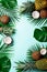 Exotic pineapples, ripe coconuts, tropical palm and green monstera leaves on blue background with copyspace for your