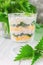 Exotic salad with nettles and eggs in a glass lined in layers