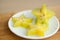 Exotic starfruit or averrhoa carambola on white plate on wooden cut board. Healthy food, fresh organic star apple fruit.