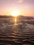 Exotic sunrise on a sandy beach with mountains in the background