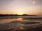 Exotic sunrise on a sandy beach with mountains in the background