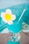 Exotic tropical Blue Curacao cocktail drink in a glass with Plumeria frangipani flower