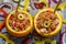 An exotically decorated dish of bulgur, poultry and vegetables with oranges. Two servings of colorful stew with spoons